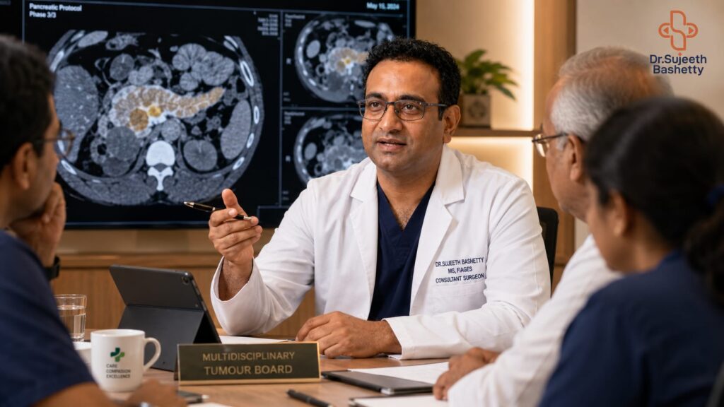 Doctor in a white coat speaks to a multidisciplinary tumor board, gesturing with a pen as CT scans fill a monitor behind him.